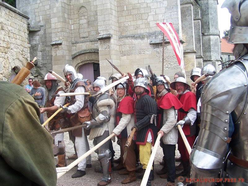Combattants en armure et cotte rouge, épées levées