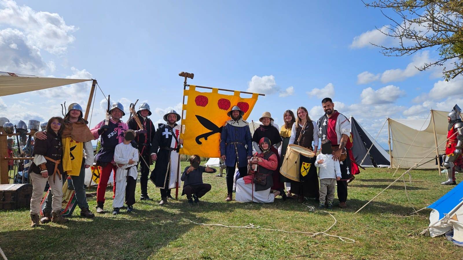 La troupe des Ganecoux en costume, réunie devant sa bannière jaune et rouge